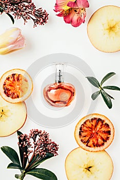 top view of bottle of perfume surrounded with fruits and flowers