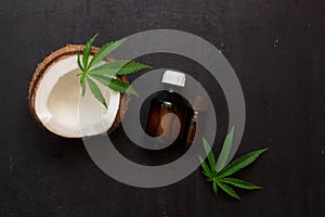 Top view bottles with coconut and cannabis oils with half of coconut