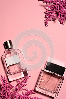 top view of bottles of perfumes with pink branches photo