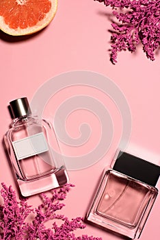 top view of bottles of perfumes with pink flowers and orange