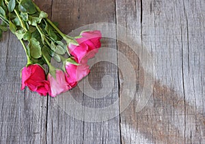 Top view of bouquet of beautiful red roses on old wooden background. Valentine`s Day concept