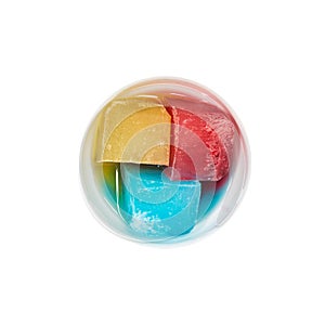 Top view of bowl with colorful ice melting on white photo