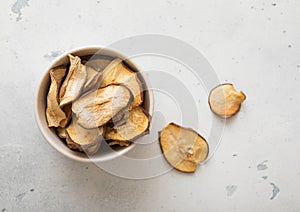 Top view of bowl with dried pear slices on light background.Macro