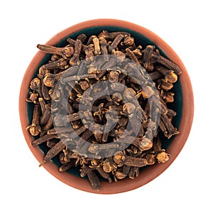 Top view of a bowl filled with whole cloves isolated on a white background