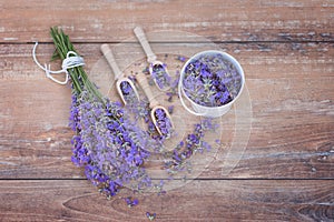 Top view of a bowl and wooden spoons with fresh lavender flowers and a bouquet of lavender