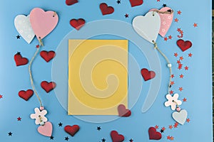 Top view of box  hearts and an envelope with free space for text on a pastel blue background.