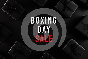 Top view of Boxing day Sale text with black gift box on dark background. Shopping concept boxing day and black Friday composition