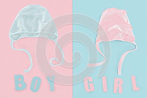 Top view of boy and girl lettering, bonnets on pink and blue background .