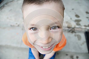 Top view boy portrait close-up . Smiling child face. Caucasian kid. fisheye effect. fish-eyed shot