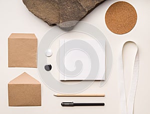 Top view branding mock-up with craft paper and square book cover on a light background