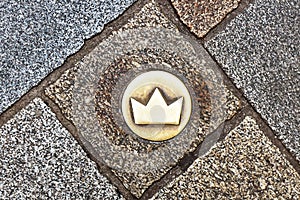 Top view of brass crown marker in cobblestone streets