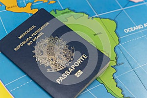 Top view of Brazilian passport over map. Focus on the South American continent. Emigration, travel, destination concept