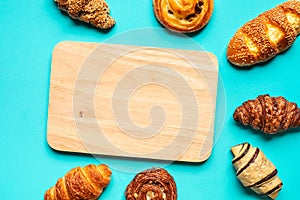 Top view of bread and bakery set with chopping board on blue color background.Food and healthy concepts