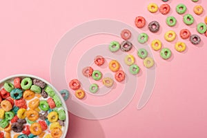 Top view of bright colorful breakfast cereal with milk in bowl and around