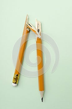 Top view of broken pencil on the light green surface.Concept of stressful situations photo