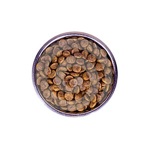 Top view of brown biscuit bones and crunchy organic kibble pieces for dog feed in a metal bowl isolated on white background.