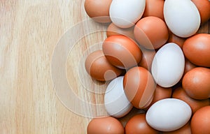 Top view of brown chicken eggs and white duck eggs on wooden  background with copy space