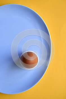 Top VIew of Brown Egg in Cup on Blue Plate
