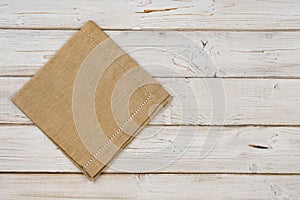 Top view of brown kitchen napkin on wooden planks background