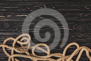 top view of brown marine rope on dark wooden planks