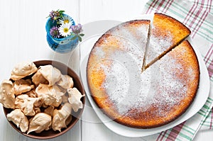 Top view: brown meringues and manna semolina pie on white wooden table