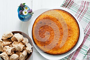 Top view: brown meringues and manna semolina pie on white wooden table