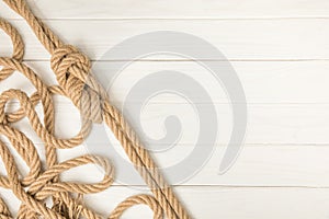 top view of brown nautical knotted rope on white wooden planks