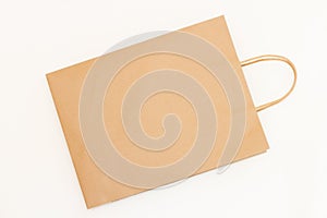 Top view brown paper shopping bag on white background. Empty craft paper bag