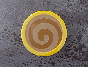 Top view of brown turkey gravy in a small yellow bowl on a gray background photo
