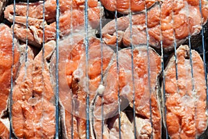 Top view of the browned steaks of red coho salmon fried on charcoal in a barbecue on a summer day in the country. Cooking a