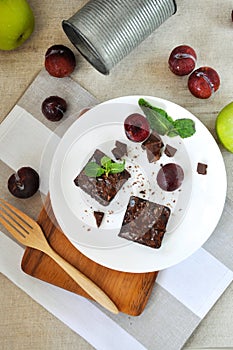 Top view of Brownies on White Plate with Fresh Plum