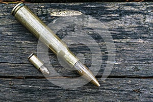 Top view of bullets on wooden background.