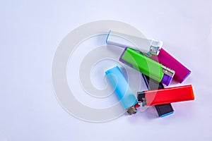 Top view of a bunch of different colors and designs of lighters. Gas, plastic disposable gas lighters. 123