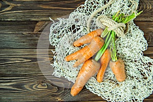 Top view Bunch of Fresh organic dirty carrots from farm market on the wooden background. Vegetables. Healthy food concept. Vegetar