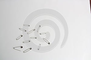 Top view of a bunch of safety pins on a white background