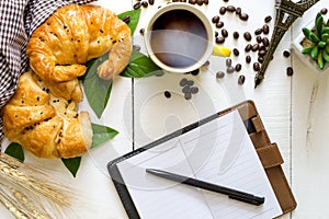 top view business breakfast with coffee and croussant. Rustic white wooden background with copy space