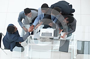 top view. business colleagues shaking hands during office meeting.