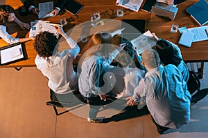 Top view of business conference, meeting. Young colleagues, co-workers, students during work process at office, indoors