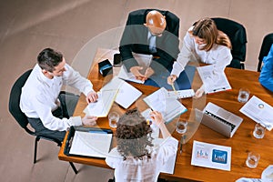 Top view of business conference, meeting. Young colleagues, co-workers, students during work process at office, indoors