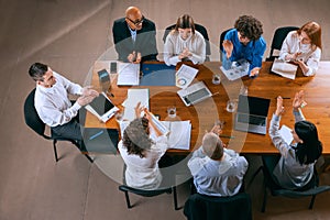 Top view of business conference, meeting. Young colleagues, co-workers, students during work process at office, indoors