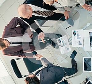 top view. business people shaking hands in the meeting room.