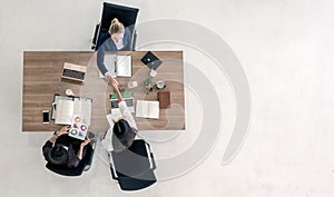 Top view of business people shaking hands after sealing a deal. High angle view of casual businesswomen handshake