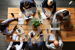 Top view of business people sitting at table and working together in office, Business team collaborating around a table, top view