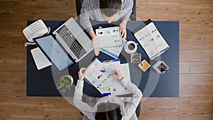 Top view of business women comparing financial graphs with management statistics expertise