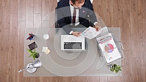 Top view of businessman analyzing company statistics documents working at financial strategy