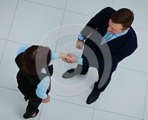 Top view of a businessman and businesswoman shaking hands - Welcome to business.