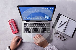 Top view of a businessman laptop computer with analytics data concept on screen.