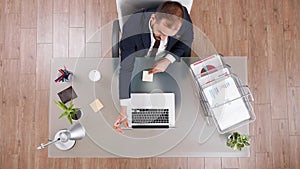 Top view of businessman putting stickey notes on laptop while working at company investments