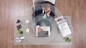 Top view of businessman in suit discussing online profit with manager at phone