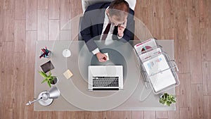 Top view of businessman talking at phone with partner writing corporate profit on stickey notes